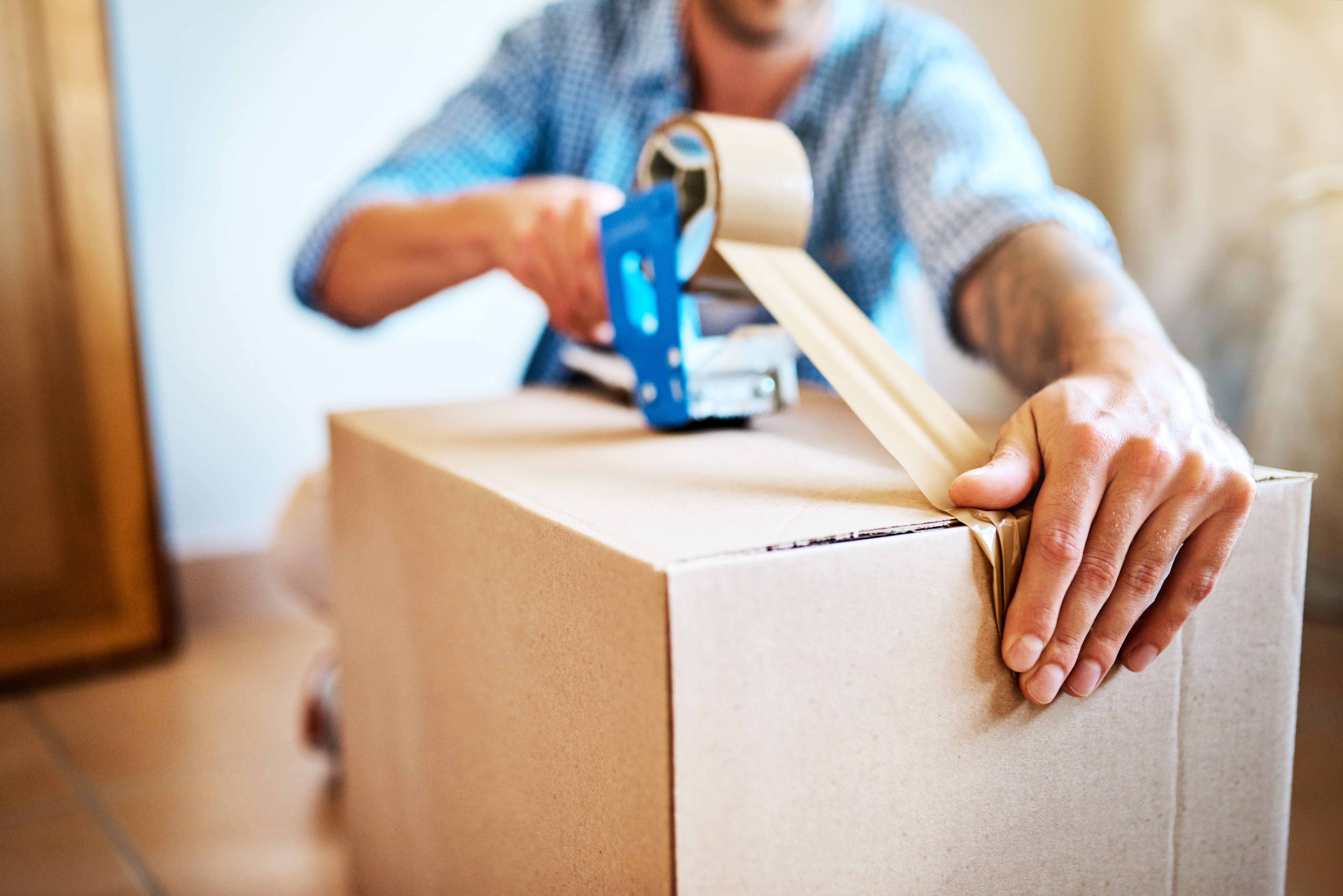Person taping cardboard box